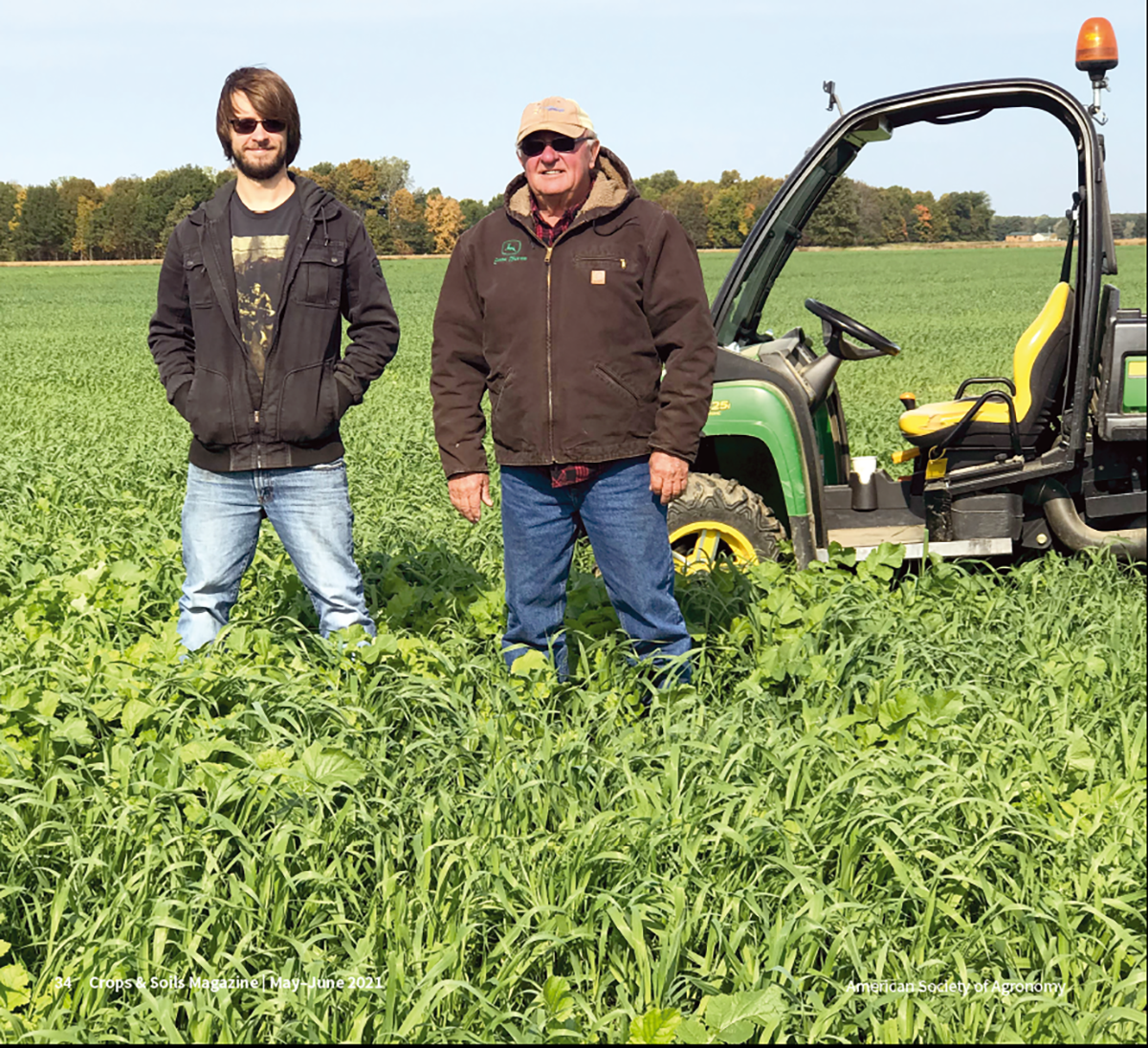 A Michigan grower and his grandson standing in a field of mixed cover crop species, which provide numerous benefits, including the ability to have an advantage when bidding for rented land.