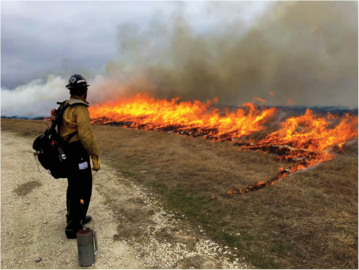 A prescribed burning crew member monitors a patch of burning rangeland. Photo courtesy of the USEPA.