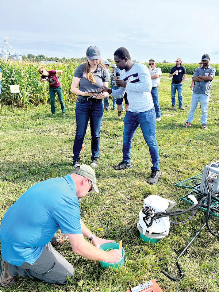 Perejiti Bekewe demonstrates a LI-COR unit to Cornell Cooperative Extension Educator Katelyn Miller and SWCD employee Brian Hall at the Cornell Field Crop Annual Field Day on the research farm in Aurora, NY.