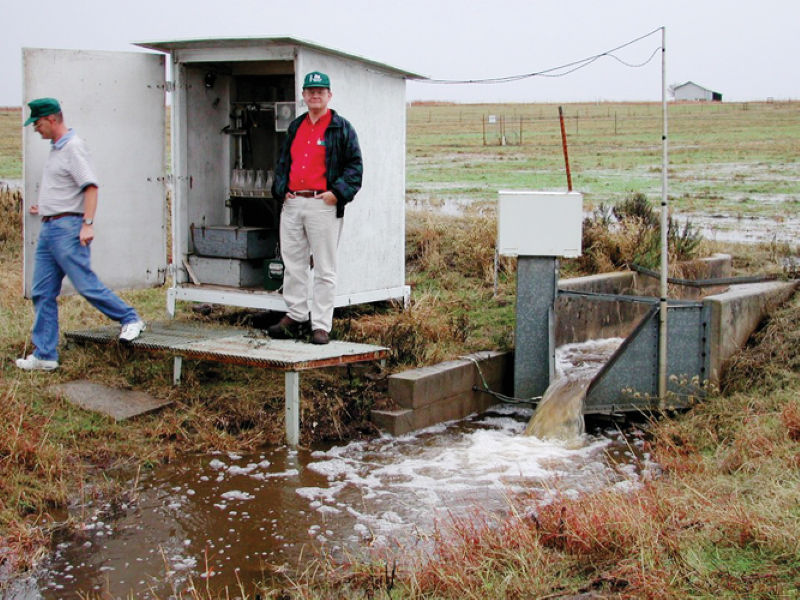 Patrick Starks (left) and John Ross standing in front of the housing for one of the Chickasha samplers in 2000.