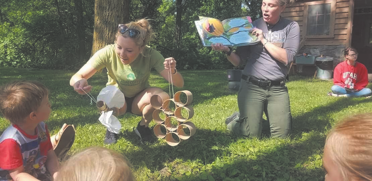 Paula Comeau (left) and North Dakota State University Natural Resource Management Club Member Claire Campion teaching kids about pollinators.