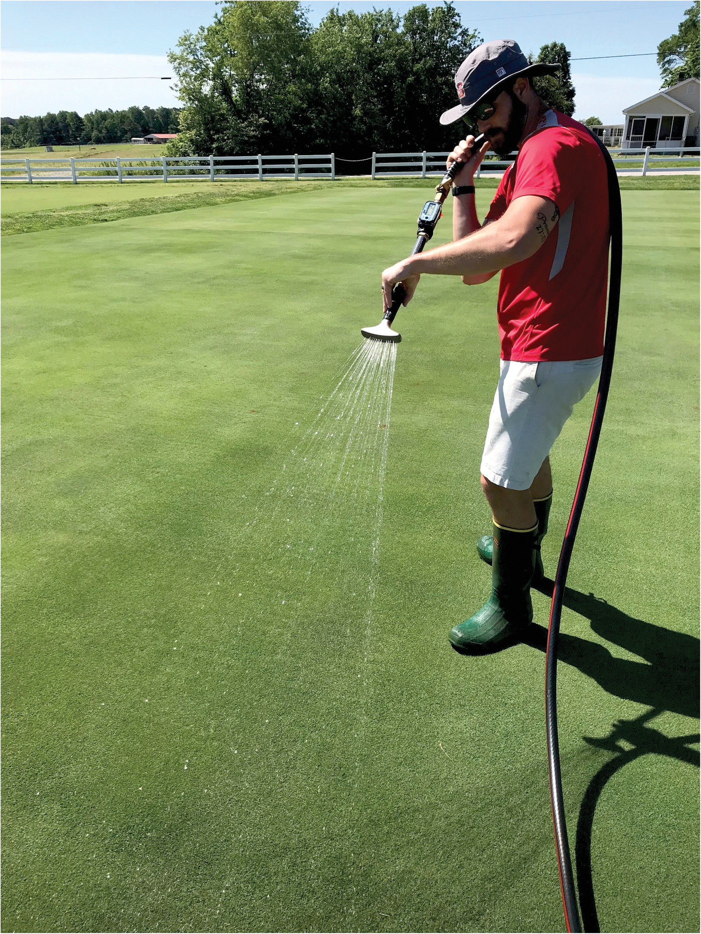 Cameron Stephens applying post-application irrigation to field research plots to evaluate the influence of its timing on fungicide movement on a golf course putting green. Photo by Daniel Freund.