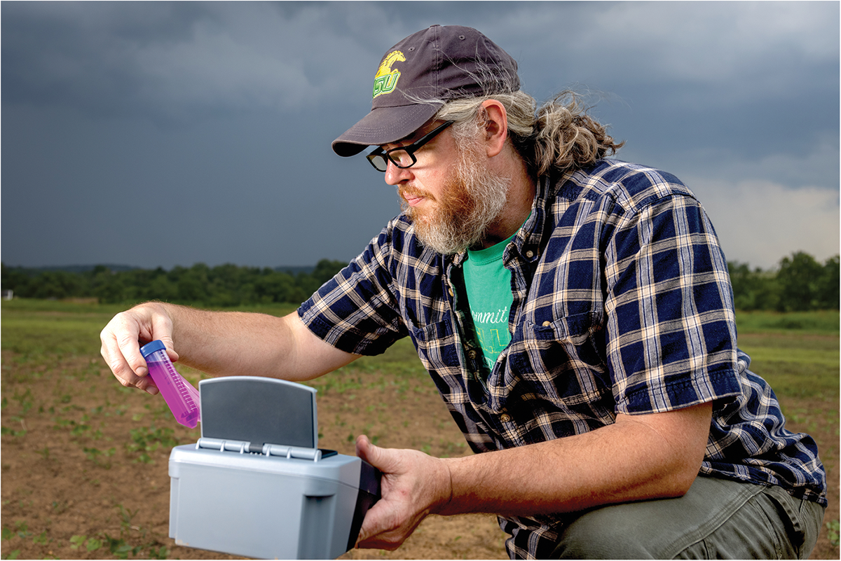 Co-author Shawn Lucas gathers information on the soil carbon status of a field by analyzing permanganate oxidizable soil carbon. Modern handheld spectrophotometers make this rapid and practical method easy to incorporate into field assessment kits. Photo by Jonathan Palmer.