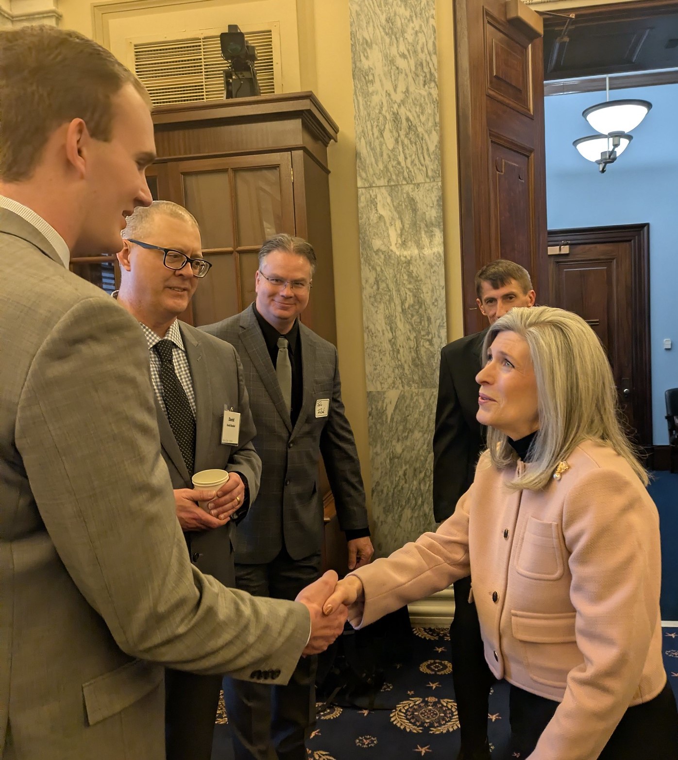 Sen. Joni Ernst shakes a constituent's hand