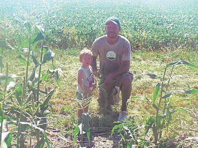 2020 CCA of the Year Adam Kramer with his son, Ezra, working in a sweet corn patch.