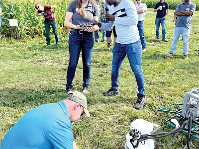 Perejiti Bekewe demonstrates a LI-COR unit to Cornell Cooperative Extension Educator Katelyn Miller and SWCD employee Brian Hall at the Cornell Field Crop Annual Field Day on the research farm in Aurora, NY.