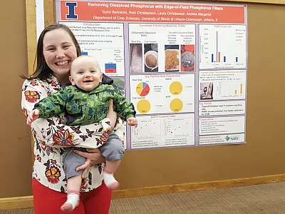 Graduate student Taylor Berkshire with her son after presenting her research at a workshop to stakeholders and other researchers.