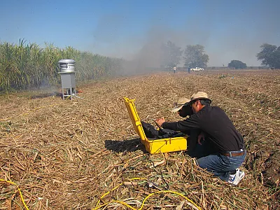 Collecting particulate matter samples from a biomass-burning event of sugarcane before harvest. Photo by Jim Wang.