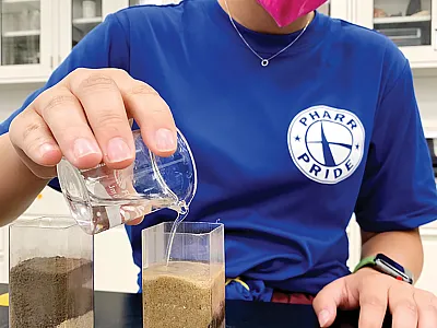 Texas A&M undergraduate Soil Science major Ariana Lazo compares water movement from clay to sand and sand to clay in small water columns. Photo courtesy of Andrea Fonseca.