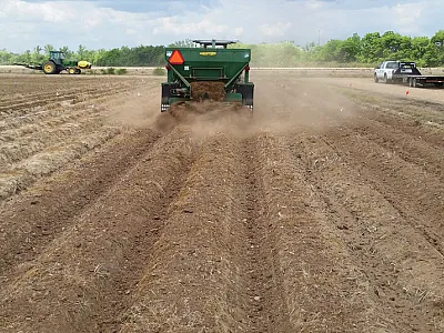 Application of poultry litter with a small-plot manure spreader in a study that investigated methods of managing nutrient buildup due to repeated poultry litter applications. Photo by H. Tewolde.