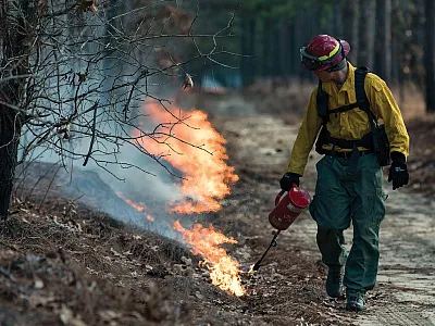 Air Force Staff Sgt. Cody Nell lights a controlled burn, which helps prevent future wildfires. SERDP and ESTCP support management-relevant science for fire managers and researchers with a focus on next-generation fire behavior and smoke dispersion models.