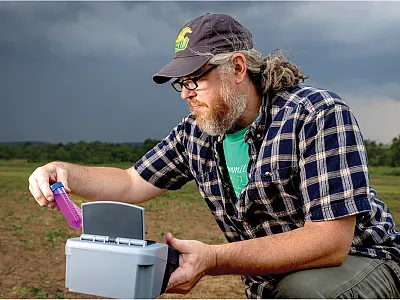 Co-author Shawn Lucas gathers information on the soil carbon status of a field by analyzing permanganate oxidizable soil carbon. Modern handheld spectrophotometers make this rapid and practical method easy to incorporate into field assessment kits. Photo by Jonathan Palmer.