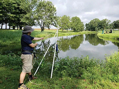 Lead author Matthew Stocker lowers a sonde into an irrigation pond to measure water quality. Photo courtesy of Matthew Stocker.