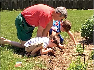 When one retires from full-time employment, the flexibility to contribute more to family support (parents and grandchildren) and fun time, hobbies, travel, etc. is appreciated and important. Here, Paul Carter shows his grandsons how to sow flower seeds in garden borders.