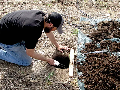 Lead author Pedro Rossini installs soil water reflectometers in a commercial field at the Flickner Innovation Farm. Photo courtesy Andres Patrignani.