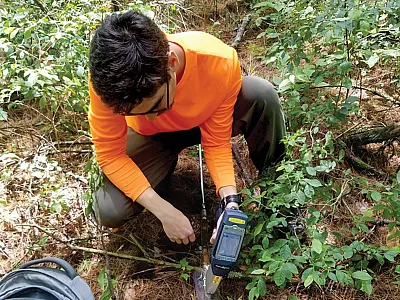 First author Mark Higgins measuring arsenic and lead levels in soils at depth using an X-ray fluorescence device and soil probe. Photo courtesy of Meredith Metcalf.