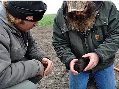 Producer Tony Wagnerand and Lee Briese, Certified Crop Adviser and Society member (right), look at soil quality. Photo by Abbey Wick.
