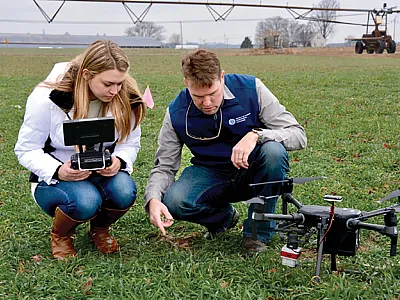 University of Delaware graduate student Jamie Taraila (left) and first author Jarrod Miller evaluate research plots to perform multispectral drone imagery. Photo by Michele Walfred.