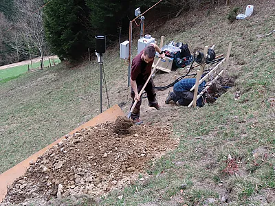 Florian Schläfli (left) and Dr. Adrian Wicki install in situ soil wetness sensors to validate the saturation values derived from electrical resistivity tomography. Photo by Stefan Boss.