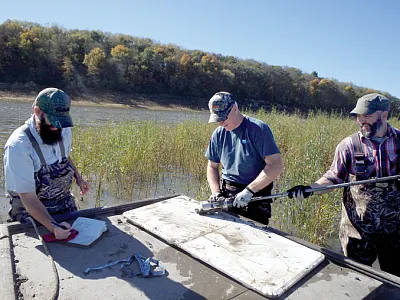 Researchers (l to r: Matthew Streeter, Keith Schilling, and Tom Stoeffler) from the Iowa Geological Survey collect a soil sample  from the Lake Red Rock delta in central Iowa. Photo by Todd Goss- elink, Iowa Department of Natural Resources.