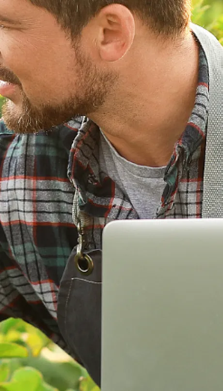 person in a large crop with computer in hand